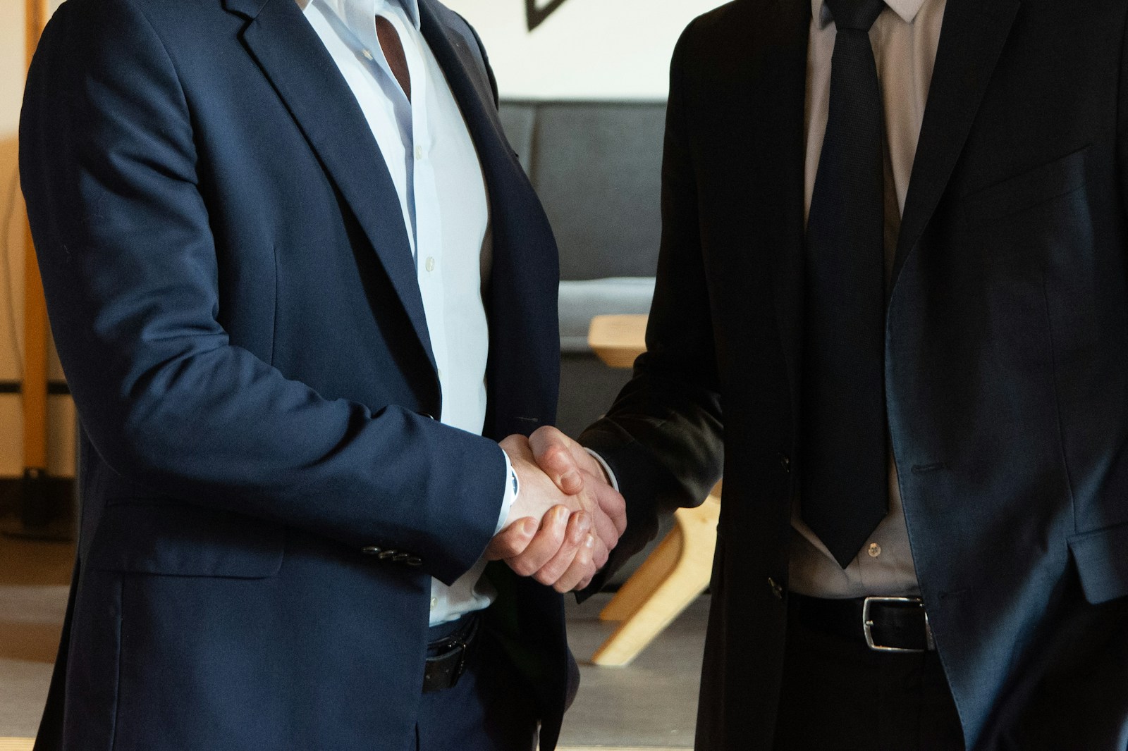 Photo by Ambre Estève Two business partners shaking hands in agreement.